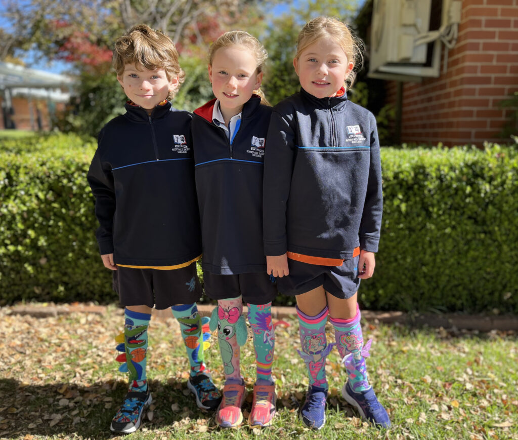 Three primary school students standing outside