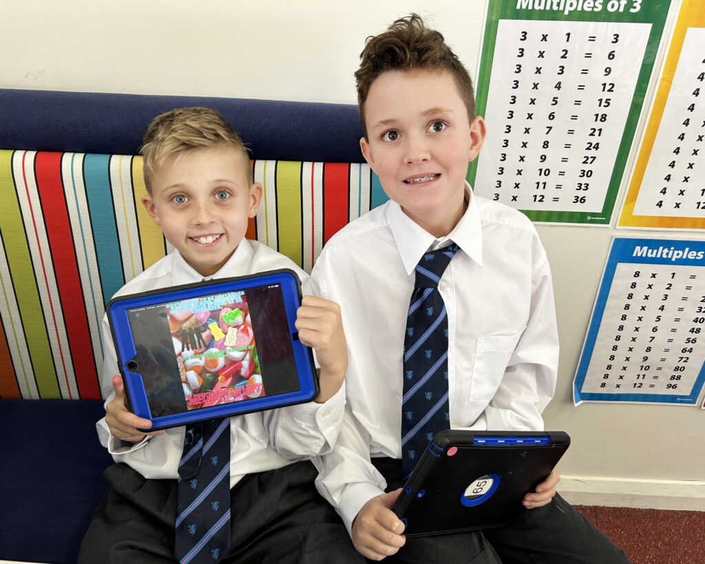 Two primary students sitting in library with ipad